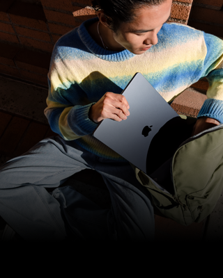 ミッドナイトの15インチMacBook Airをリュックにしまう人物