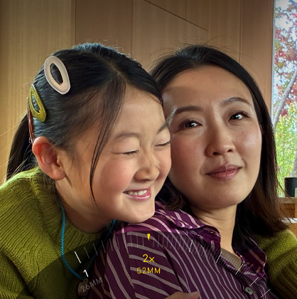 2倍望遠機能を使って、抱き合う2人の人物にズームインしている